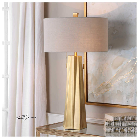 Ceramic table lamp with a gently curved body and soft linen drum shade, diffusing a warm, ambient glow—ideal for adding cozy elegance and sculptural charm to living spaces